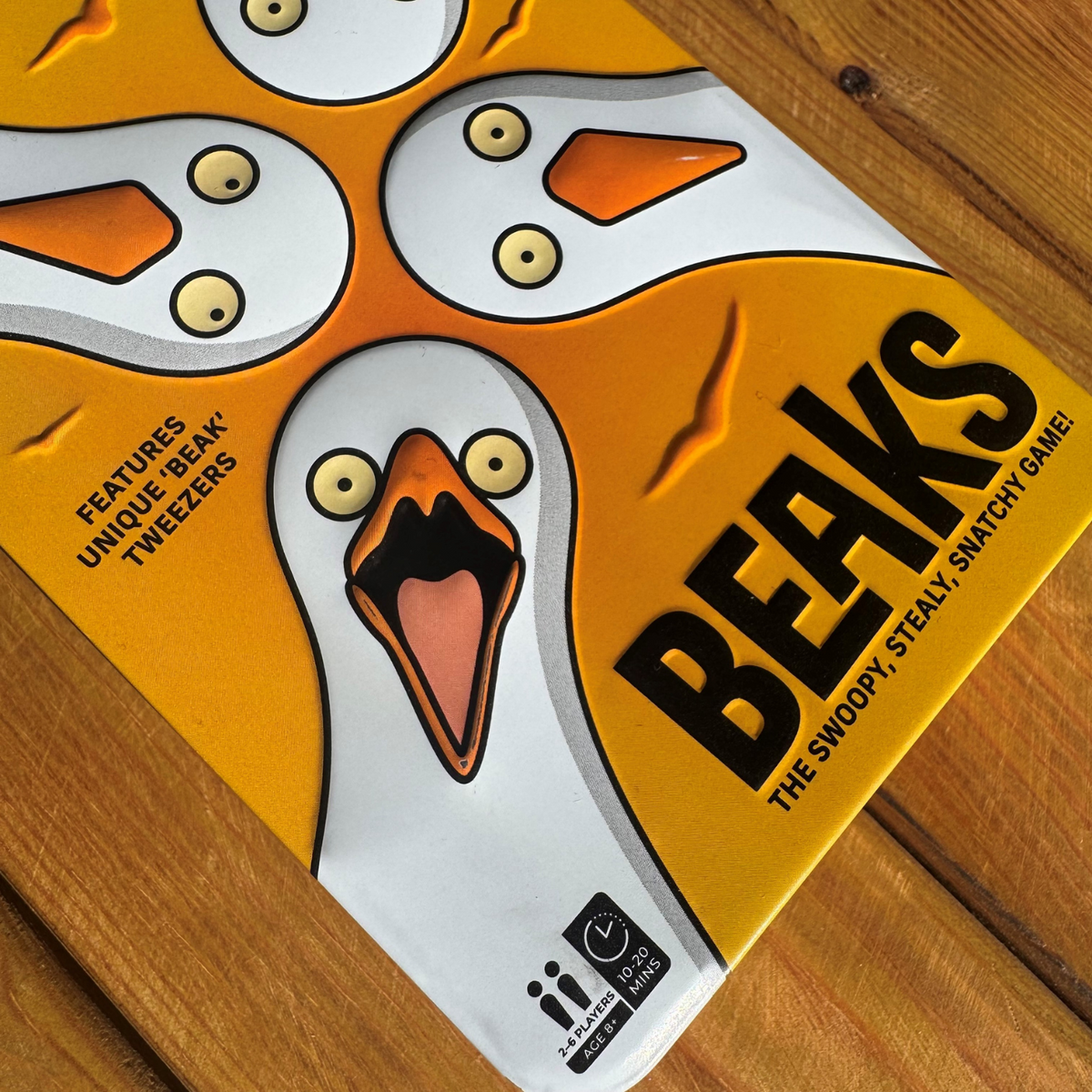 Board game box for &#39;Beaks&#39; with cartoon duck design on a wooden surface
