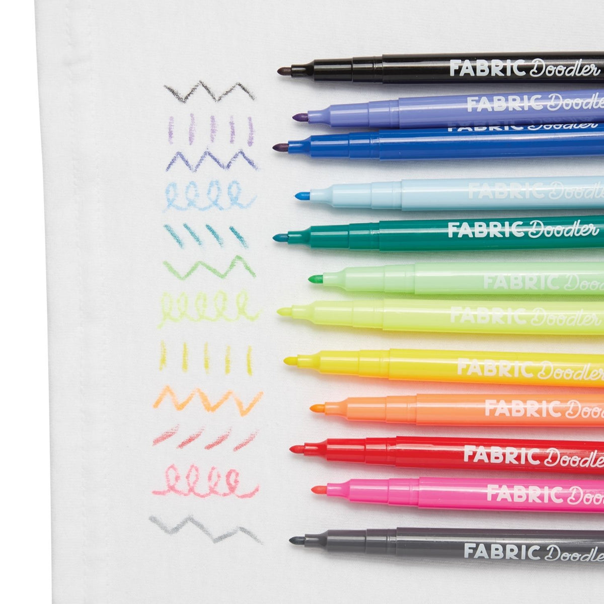 Fabric Doodler markers in various colors on a white background with sample designs.