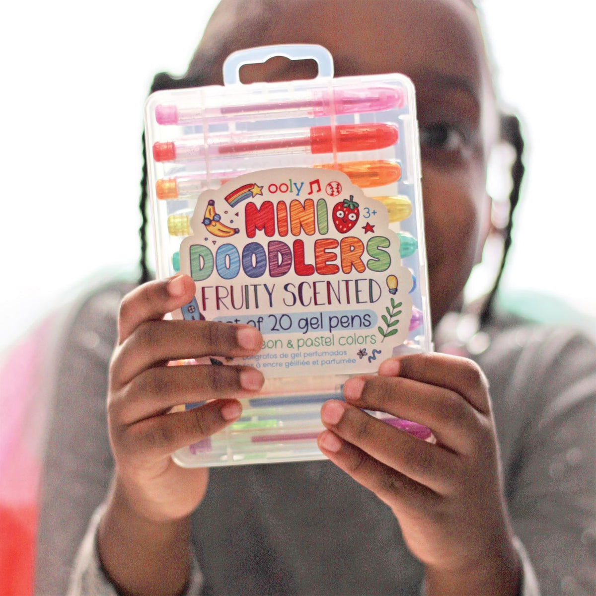 Person holding a package of Ooly Mini Doodlers gel pens with colorful packaging.