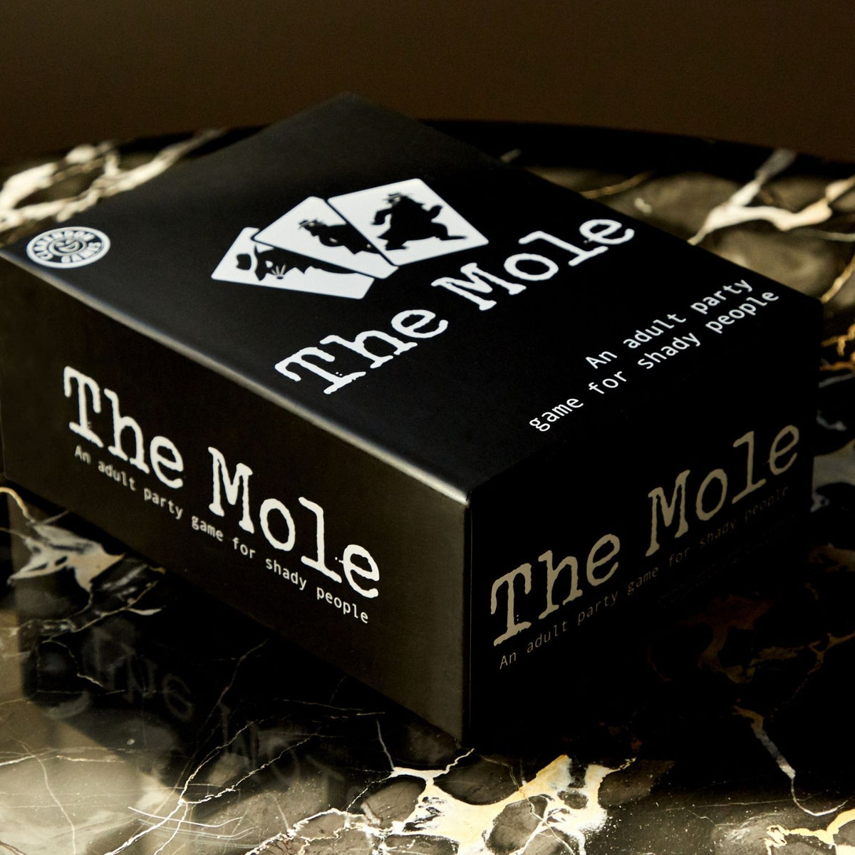 A close-up shot of the packaging spine, highlighting the clear text icons for player count (3+ players), adult age rating (17+), and the fast 10-to-20-minute playtime.