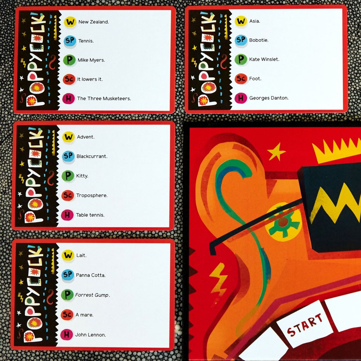 Colorful board game components with text and graphics on a black background