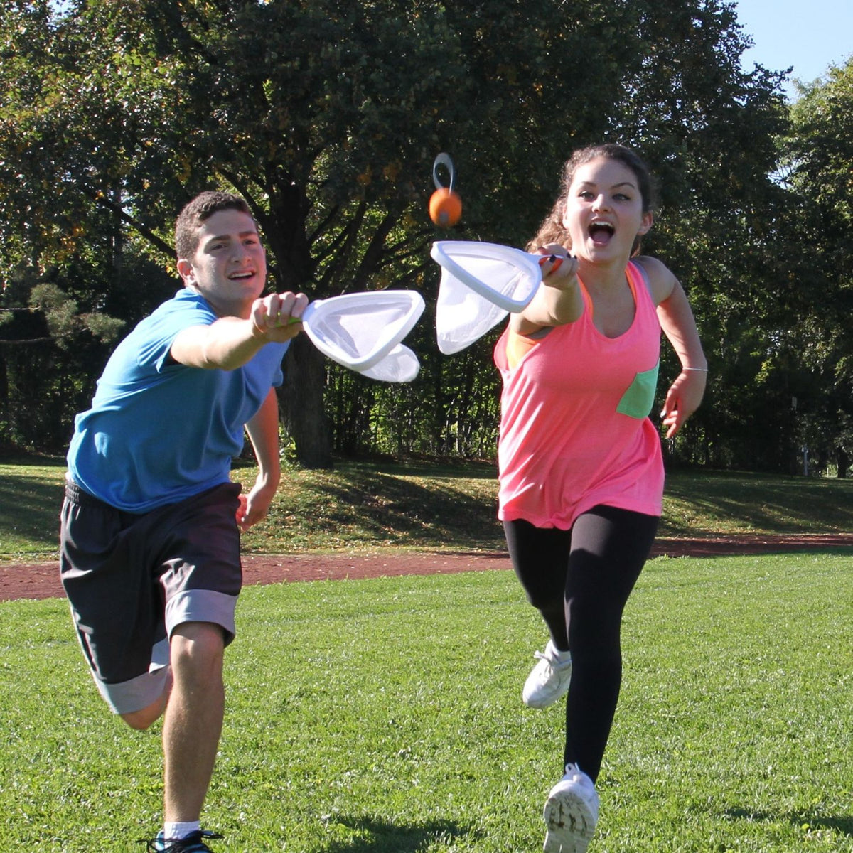 Two people catching a SlingBall ball in a park