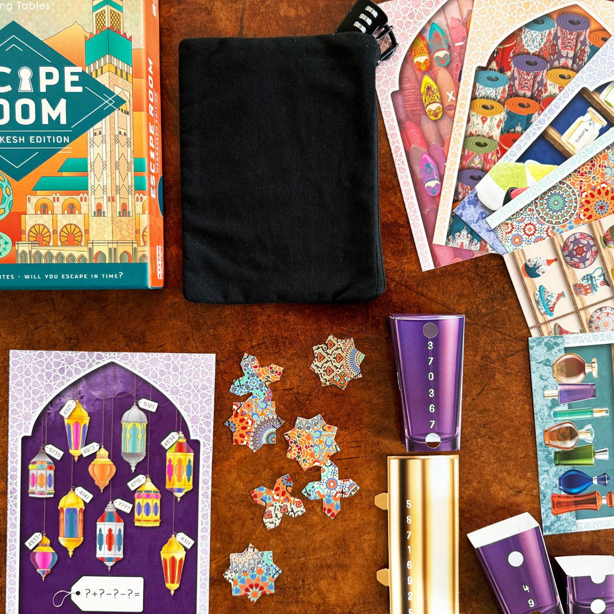 Collection of items including a book, black pouch, and decorative cards on a wooden surface.