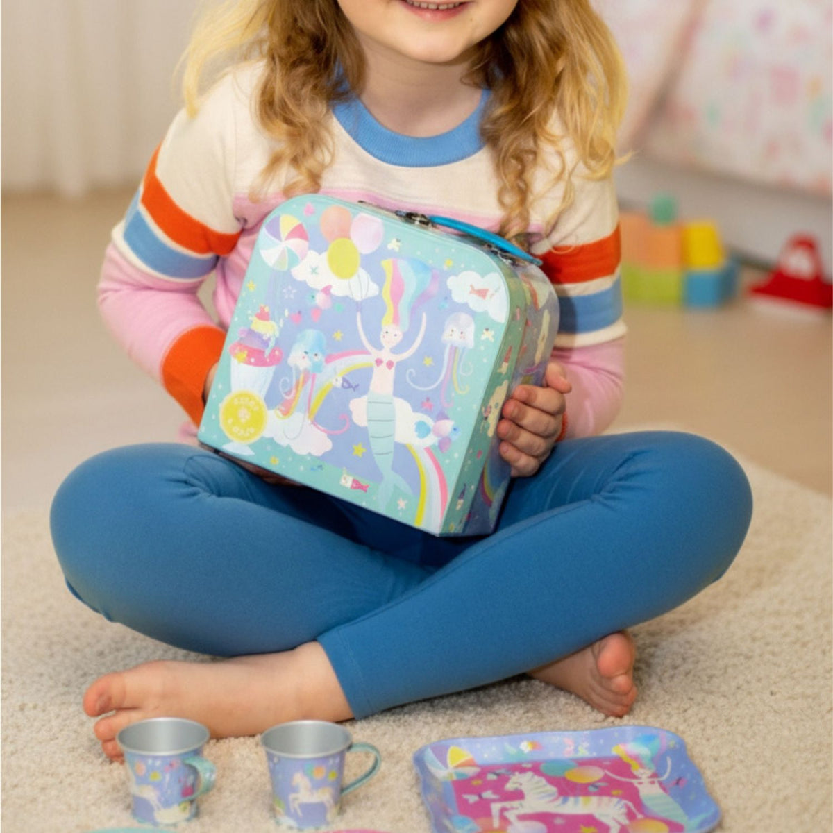 A colourful carry case with a sturdy handle, decorated with playful fantasy characters like toucans, jellyfish, and unicorns.