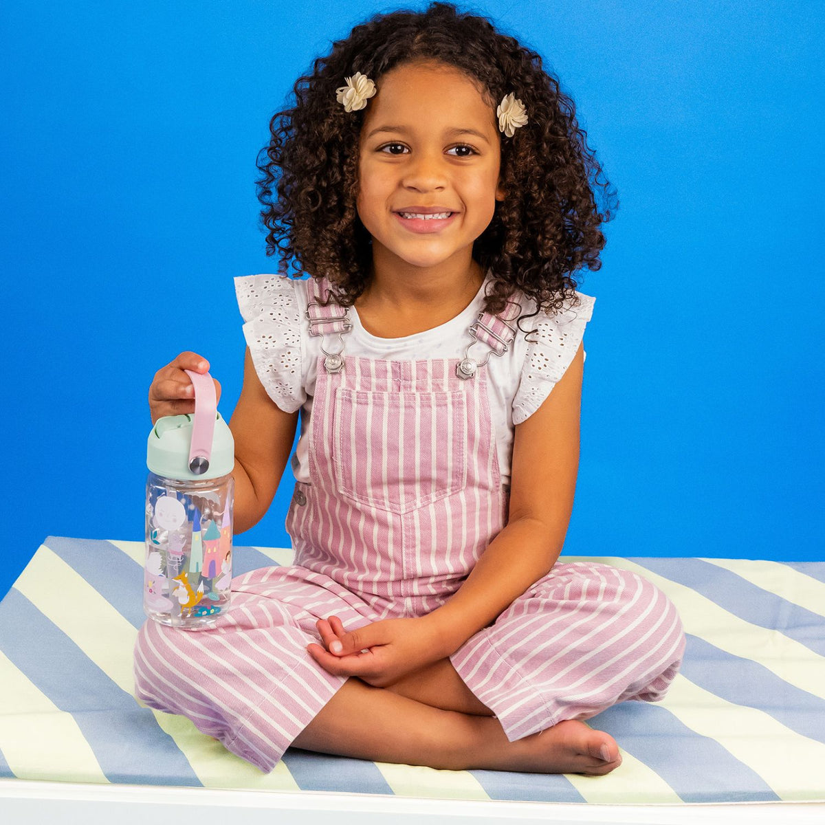 Young girl holding a water bottle with enchanted fairy design.