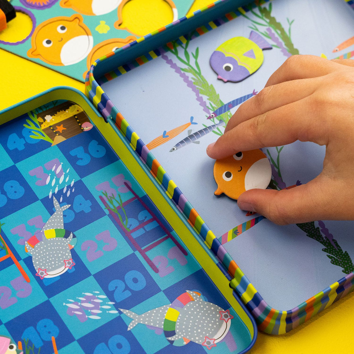 Colorful children's educational toy with magnetic elements and a hand interacting with it.