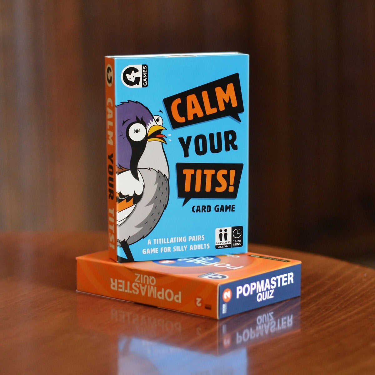 Card game box titled 'Calm Your Tits' on a wooden surface 