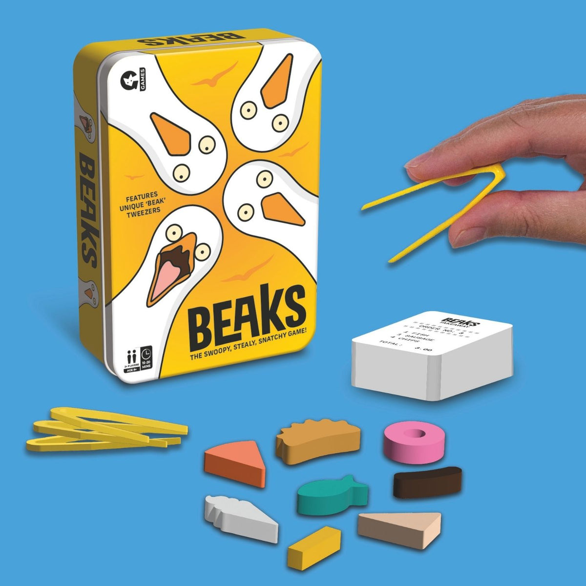 Beaks game components including box, pieces, and a hand holding a yellow tool on a blue background