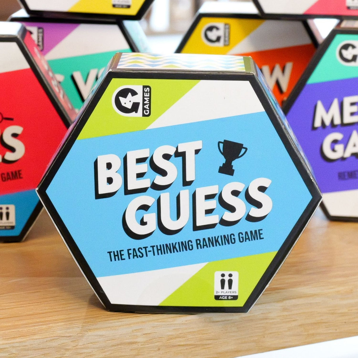 Hexagonal game box labeled 'Best Guess' on a wooden surface with other colorful game boxes in the background.