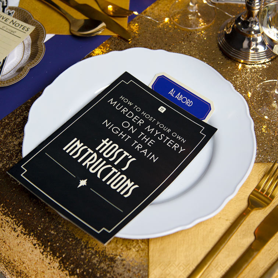 Host's instructions for a murder mystery night on a decorative table setting with gold accents.