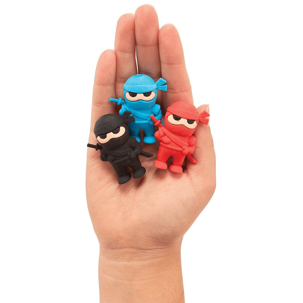 Three small ninja erasers in black, blue, and red held in a hand