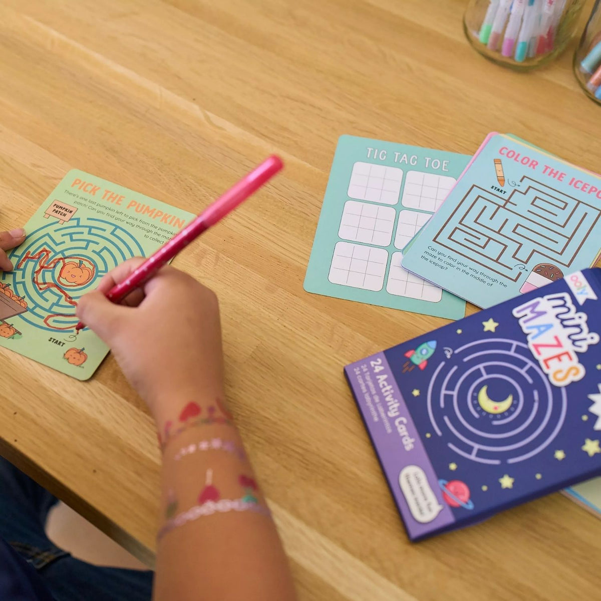 A child using the maze cards at a table, showing how they provide quiet, screen-free entertainment in public spaces.