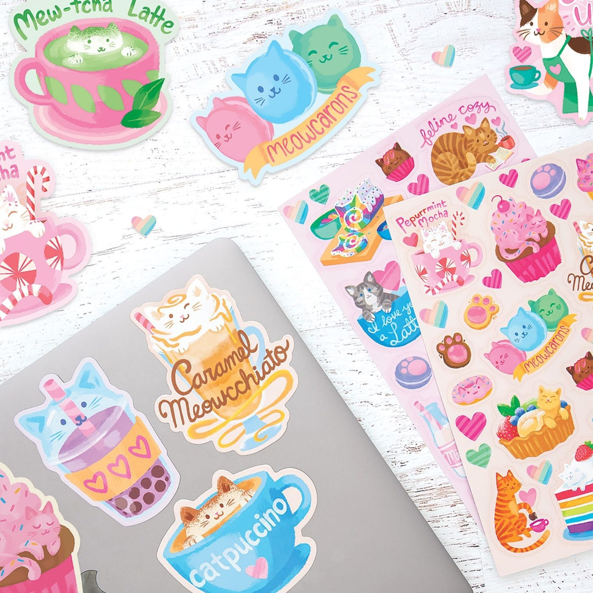 Collection of colorful cat-themed stickers on a wooden surface