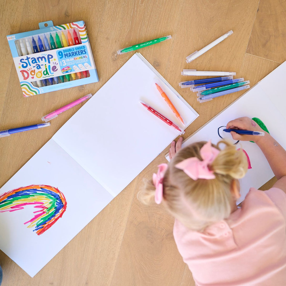A child’s hand using the star stamper on top of a blue coloured area, showing the "magic" colour change happening in real-time.