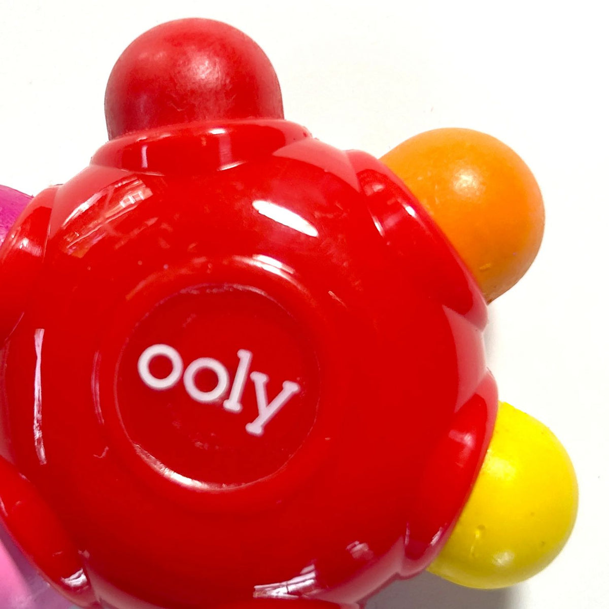 A close-up of a single flower-shaped crayon, showing six different coloured tips on each of the petals for a total of 18 colours across the set.