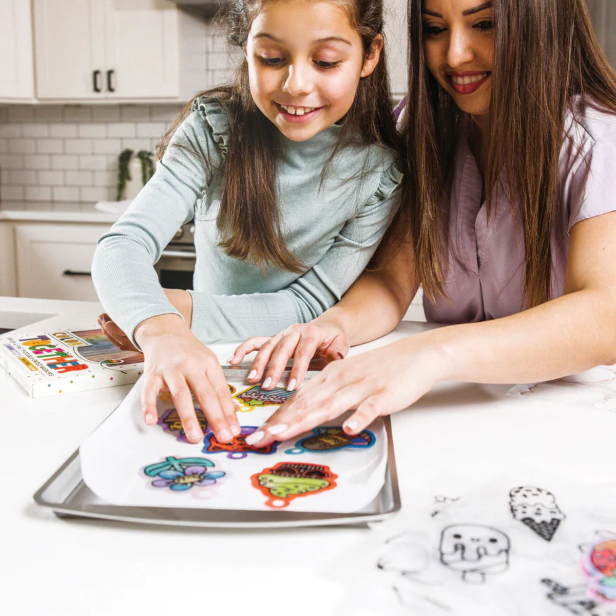 A child using coloured pencils to fill in a pre-cut shrink plastic designs, highlighting the fine motor skill development.