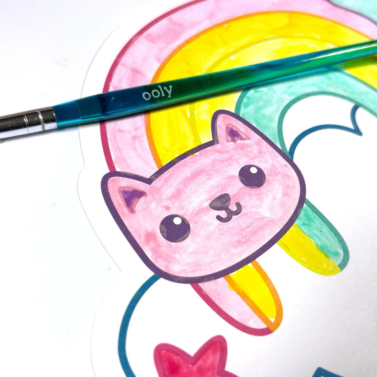 Colorful drawing of a cat with a rainbow and a 'ooly' brush on a white background