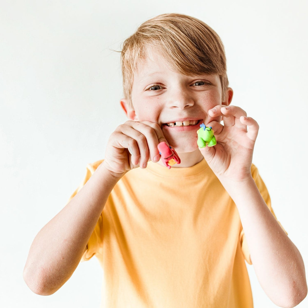 Child holding his dino-mite clay creations