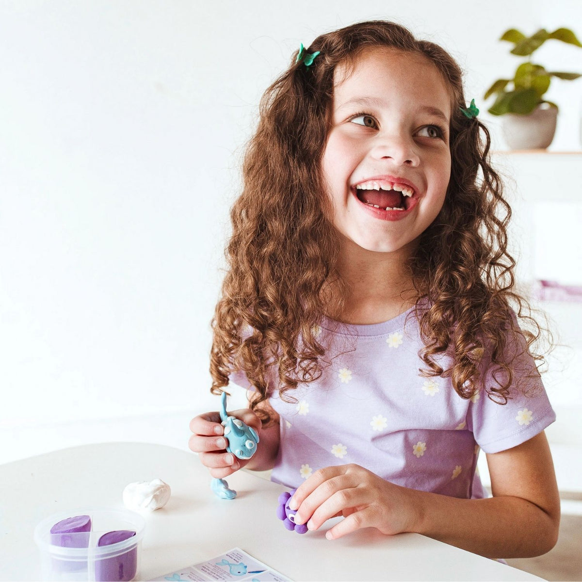 A child smiling while adding small suction cups to the octopus tentacles, illustrating the joy of 3D character design.