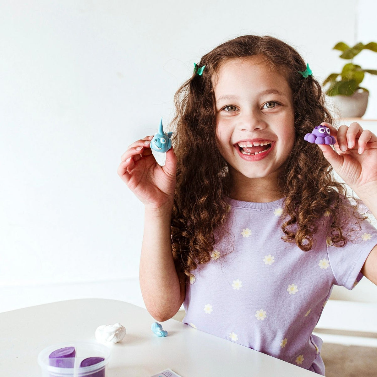 Young girl holding her finished, sturdy octopus figure, visually representing the "no-bake" magic of the air-dry process.