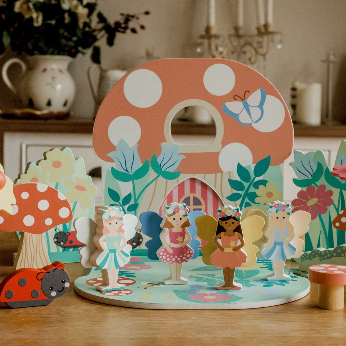 Children's fairy tale playset with colourful characters and a mushroom-shaped stand on a wooden table.