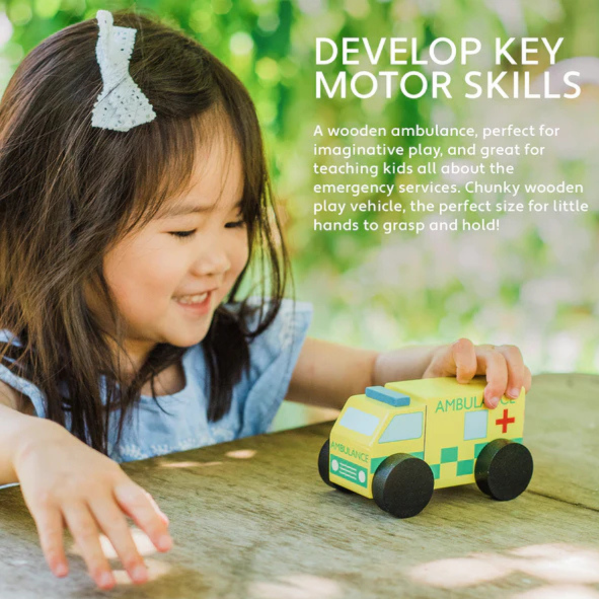 Child playing with a wooden ambulance toy outdoors