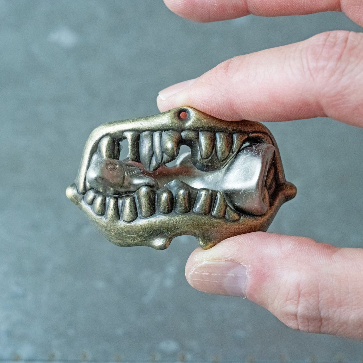 A close-up of the "Shark Bite" puzzle, featuring a small metal fish piece interlocked within a larger, shark-jaw-shaped frame.