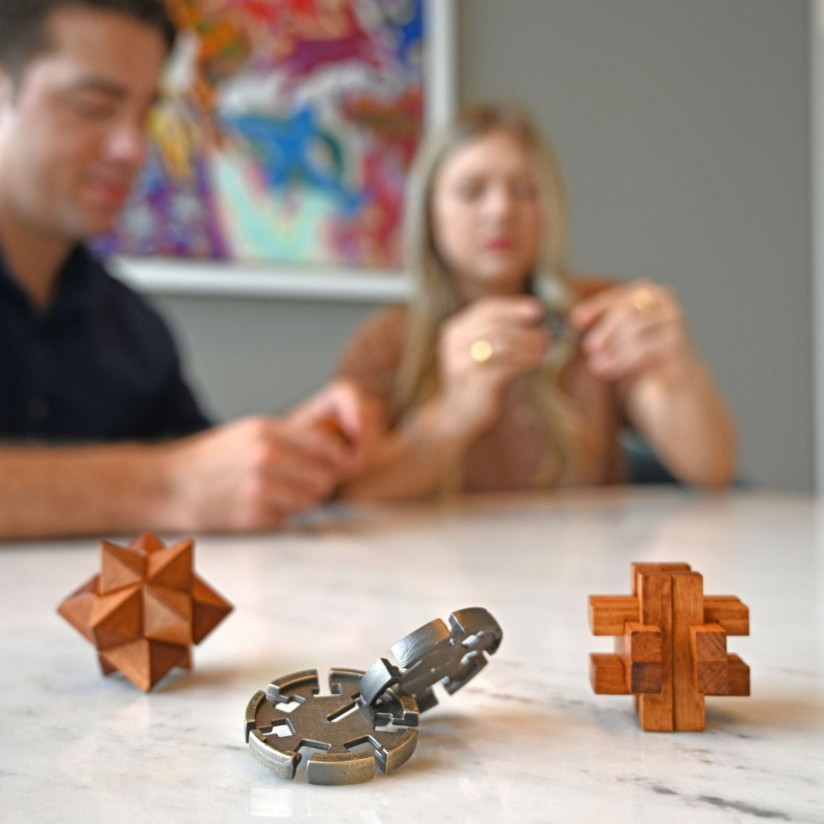 A person’s hands attempting to solve the Aztec Pok-A-Tok puzzle, demonstrating the tactile problem-solving experience of this high-quality collection.