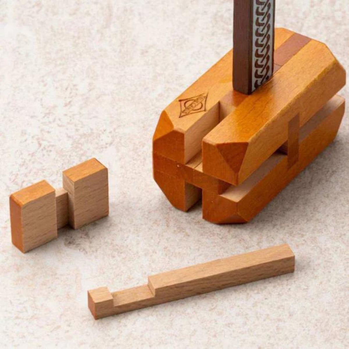 The individual wooden pieces of the Thor's Hammer puzzle laid out, showing the complex notches and shapes required for reassembly.