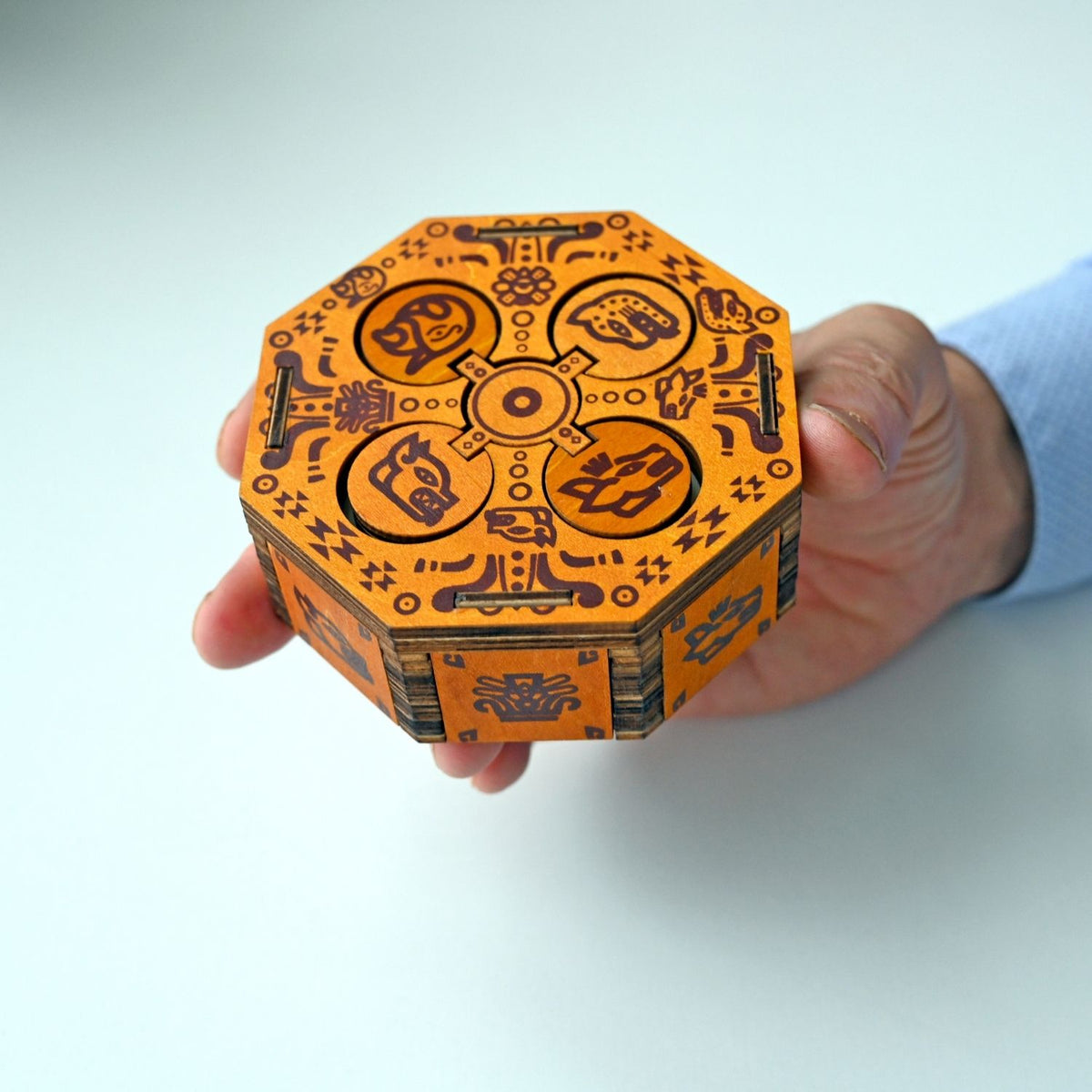 A person’s hands interacting with the sliding wooden panels to solve the level three difficulty secret box and reveal the internal chamber.