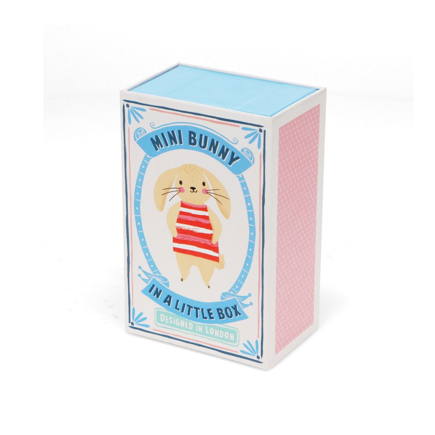 A small soft toy depicting a striped bunny in a illustrated gift box with a polka dot blanket.