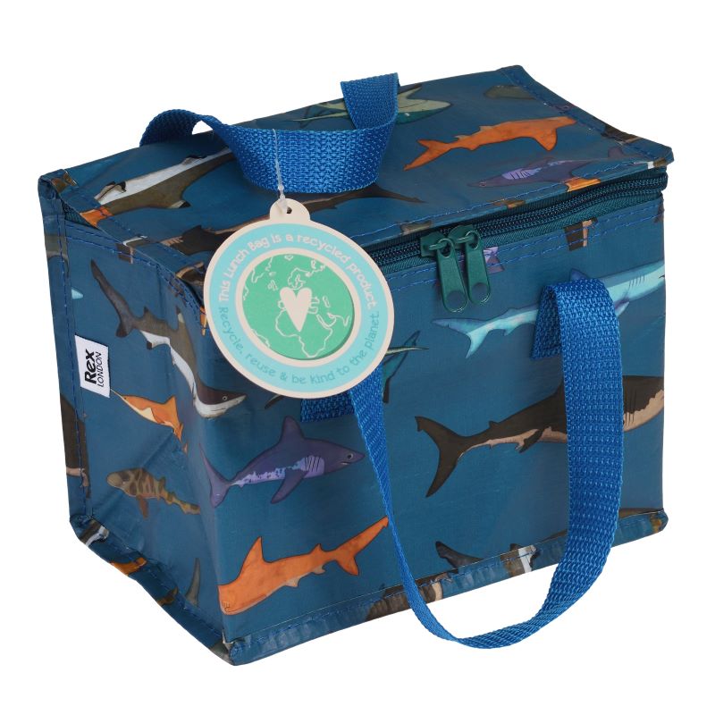 An insulated lunch bag with a blue background featuring various shark illustrations, and a recycling symbol label in the center.